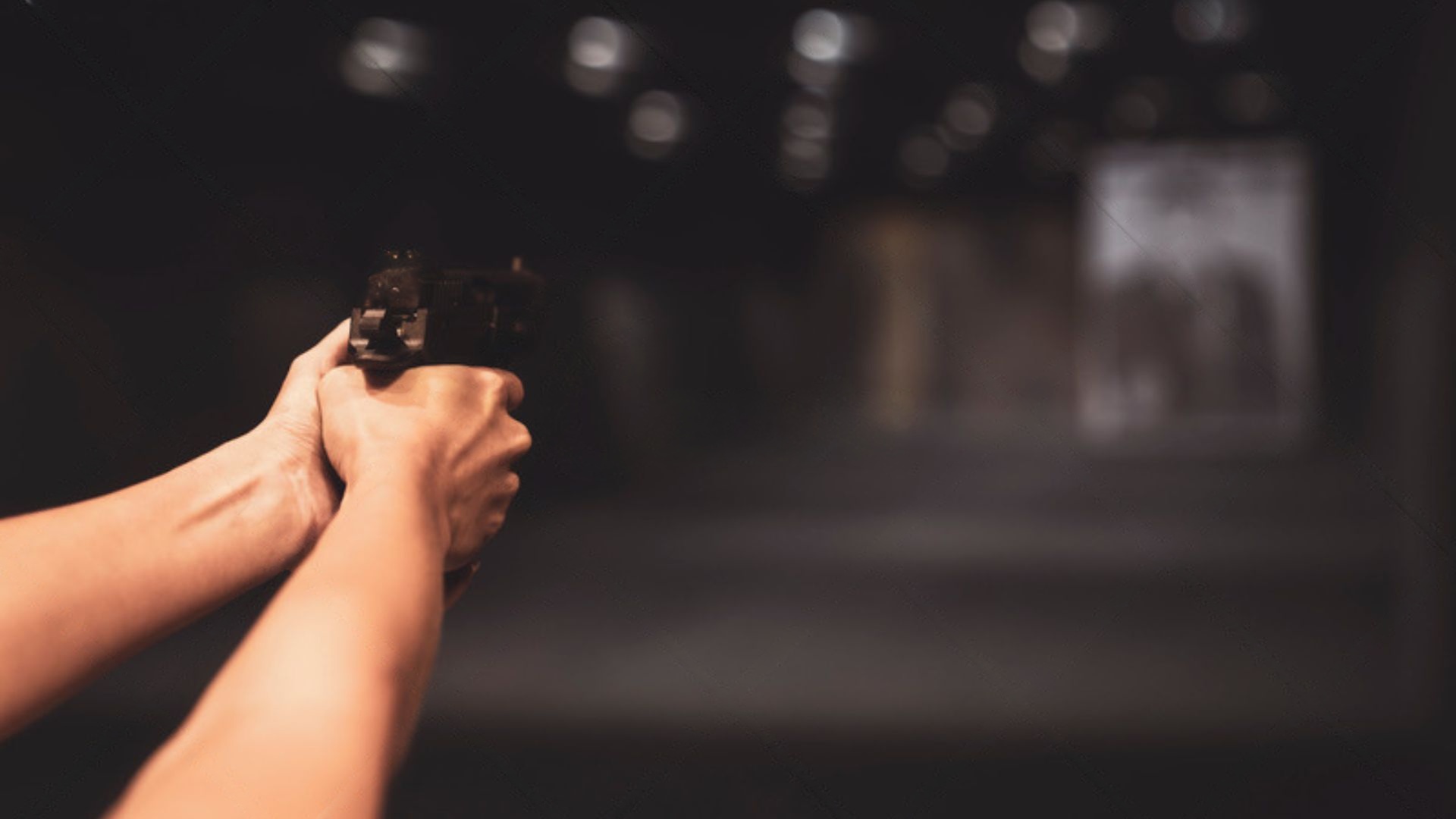 a person shooting a gun in a shooting range